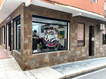 Tienda de skate abierta en esquina urbana.